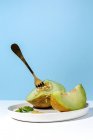 Geschnitten reif appetitlich süße entsteinte Melone auf Teller mit Gabel auf blauem Hintergrund — Stockfoto