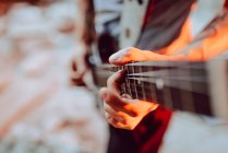 Людина затискає струни на гітарній шиї — стокове фото