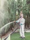 Фумігатор у білій уніформі розпилювальної речовини на саду — стокове фото