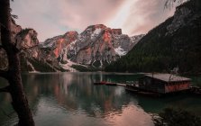 Houseboat surrounded with mountains on serene lake — Stock Photo