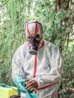 Man in suit for fumigation standing in yard — Stock Photo
