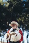 Homme âgé souriant en costume du Père Noël debout et prenant des photos avec appareil photo sur fond de nature — Photo de stock