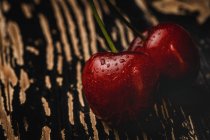 Leckere reife Kirschen auf dunklem Holztisch — Stockfoto