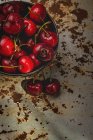 Tasty appetizing ripe cherries in bowl on rusty tabletop — Stock Photo