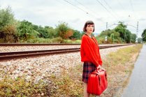 Jovem mulher de pé na estação de trem no campo — Fotografia de Stock