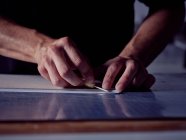 Hands of man working in bookmaking studio and measuring cover for book using pencil and ruler — Stock Photo