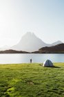 Человек купается возле палатки в горах — стоковое фото