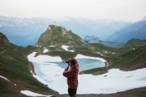 Чоловік фотографує гірський пейзаж — стокове фото