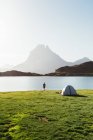 Homem perto da tenda na montanha — Fotografia de Stock