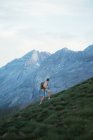 Side view of male traveler with backpack climbing foggy Pyrenees mountains — Stock Photo