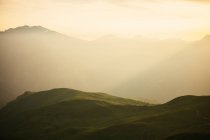 Montagne maestose tra nebbia e luce solare — Foto stock