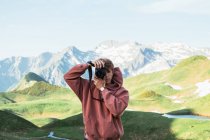 Man taking photo in mountain landscape — Stock Photo