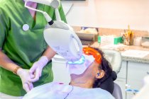 Пациент лежит в стоматологическом кресле во время рентгеновской процедуры — стоковое фото