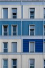 Зовнішній вигляд сучасного барвистого міського будинку з довгою половиною відкритих вузьких вікон — стокове фото