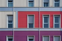 Exterior of contemporary colorful urban house with long half opened narrow windows — Stock Photo