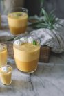 Gros plan de savoureuse mousse de mangue aromatique dans des verres sur plateau de marbre blanc — Photo de stock