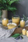 Tasty aromatic mango mousse in glasses on wooden tray with cloth — Stock Photo