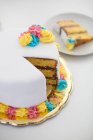 Gâteau sucré d'anniversaire savoureux avec tranche sur plaque sur surface blanche — Photo de stock
