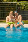 Garçons au bord de la piscine prenant selfie — Photo de stock