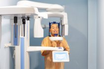 Старик в специальной защитной одежде делает рентген в стоматологическом кабинете — стоковое фото