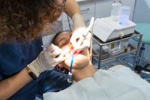Dentista haciendo la inyección con jeringa en la boca abierta del paciente i - foto de stock