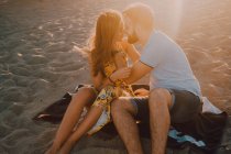 Молоді люди закохуються у зв'язок на морі в романтичний вечір заходу сонця — стокове фото