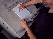 Gesichtsloser Mitarbeiter arbeitet in Druckerei mit Papier — Stockfoto