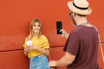 Mujer joven posando con café para hombre - foto de stock