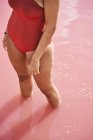 Обрезанный вид женщины в красных купальниках, позирующей в воде — стоковое фото