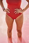 Vue recadrée de la femme en maillot de bain rouge en posture dans l'eau — Photo de stock