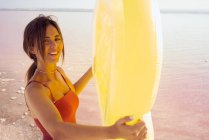 Femme sensuelle avec matelas gonflable reposant sur la plage — Photo de stock
