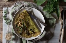 Crepe di avena con asparagi e pasta di tahini servite su piatto bianco su fondo rustico — Foto stock