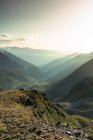 Туманный пейзаж удивительных гор при солнечном свете и путь между ними в яркий день — стоковое фото