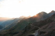 Paisagem de montanhas incríveis na luz do sol e caminho entre no dia brilhante — Fotografia de Stock