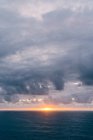Costa con erba secca vicino al mare tempestoso in serata nuvolosa durante il bel tramonto — Foto stock