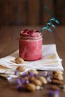 Raspberry smoothie in glass jar with almond milk served on rustic table with napkin — Stock Photo