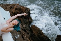 Sensual mulher despreocupada inclinando-se no cais com as costas e esticando a mão para beira-mar — Fotografia de Stock