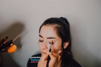 Attraktive junge Frau lässt sich von professioneller Kosmetikerin im Salon schminken — Stockfoto