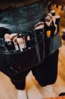 Makeup artist wearing apron bag with various brushes for work — Stock Photo
