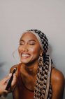 Attraktive erwachsene schwarze Frau trägt Lidschatten von professionellem Maskenbildner im Atelier auf — Stockfoto