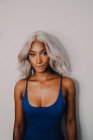 Portrait of adult African American woman with blond hair wearing blue and looking at camera — Stock Photo