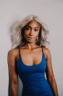 Ritratto di donna afroamericana adulta con capelli biondi che indossano il blu e guardano la macchina fotografica — Foto stock