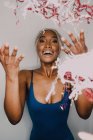 Щаслива афроамериканська жінка, яка кидає кольорові стрічки вгору і дивиться вгору — стокове фото