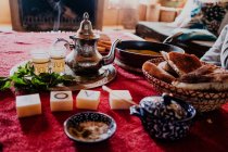 Conjunto de sobremesa árabe tradicional e bandeja com bule e copos colocados na mesa durante a cerimônia de chá tradicional — Fotografia de Stock