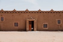 Das Äußere schäbiger traditioneller arabischer Gebäude mit Ornamenten auf der Straße einer Kleinstadt vor wolkenlosem Himmel in Marokko — Stockfoto