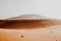 Hügel aus trockenem Sand inmitten einer großen Wüste gegen grauen Himmel in Marokko — Stockfoto