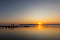 Scena romantica di una coppia al tramonto. Colori intensi di un tramonto con riflessi nell'acqua — Foto stock