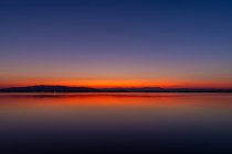 Couleurs intenses d'un coucher de soleil avec des reflets dans l'eau — Photo de stock