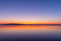 Colores intensos de una puesta de sol con reflejos en el agua - foto de stock