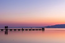 Anonyme Touristen auf der Seebrücke bei Sonnenuntergang — Stockfoto